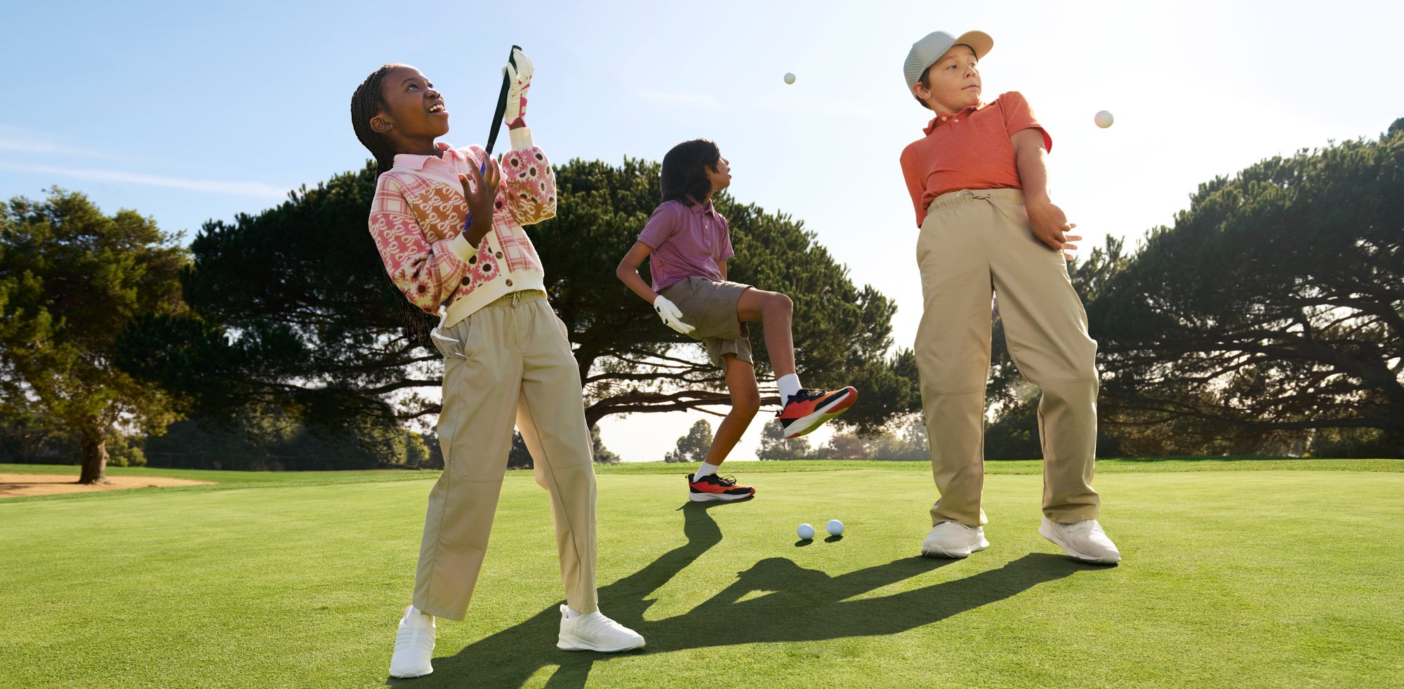 Three youth golfers joyfully play around on a beautifully maintained course