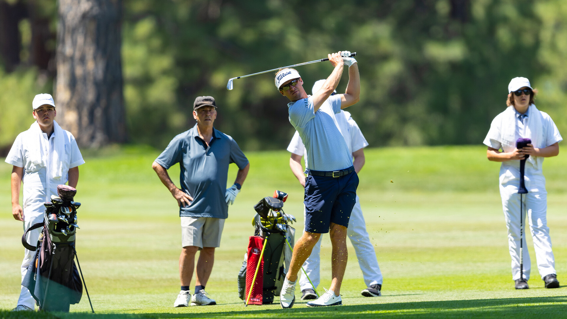 Youth on Course members caddying for amateurs alongside pros