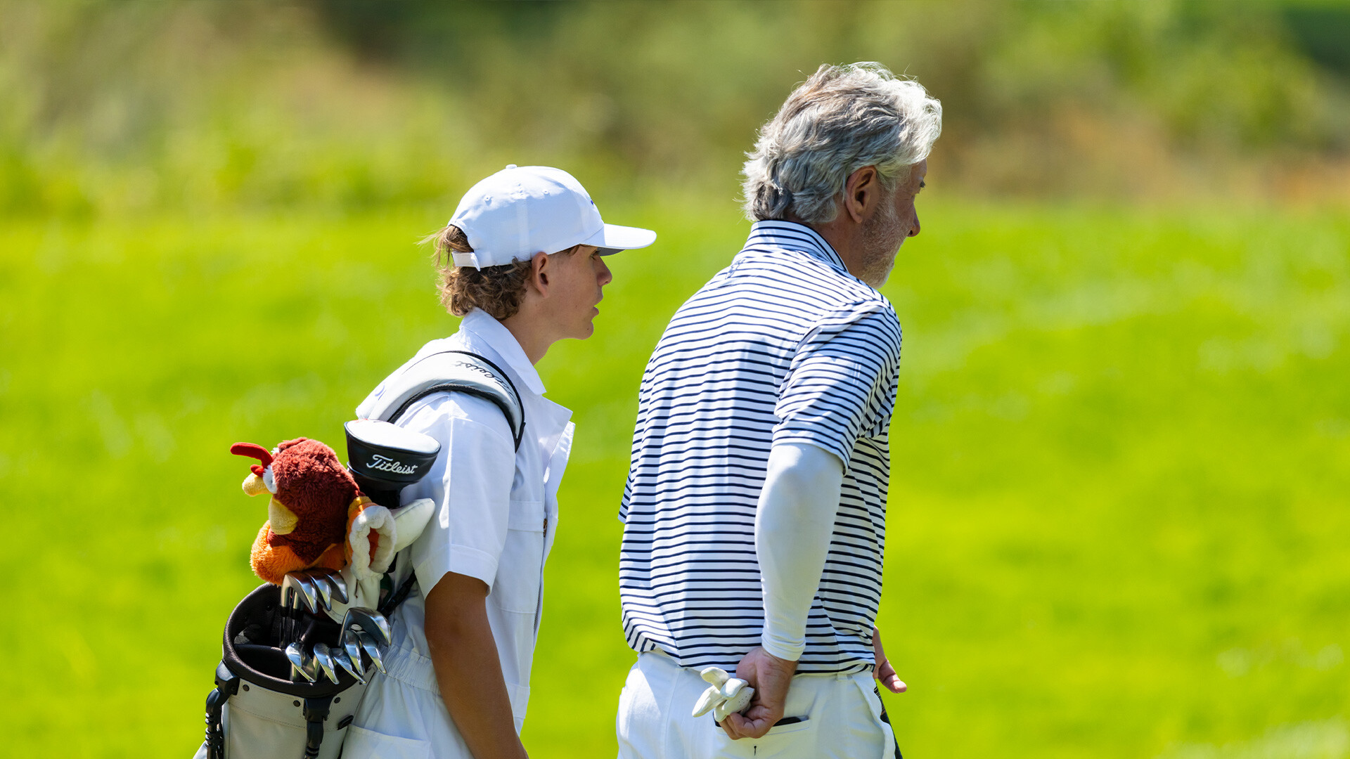 Youth on Course member caddying for amateurs alongside pros