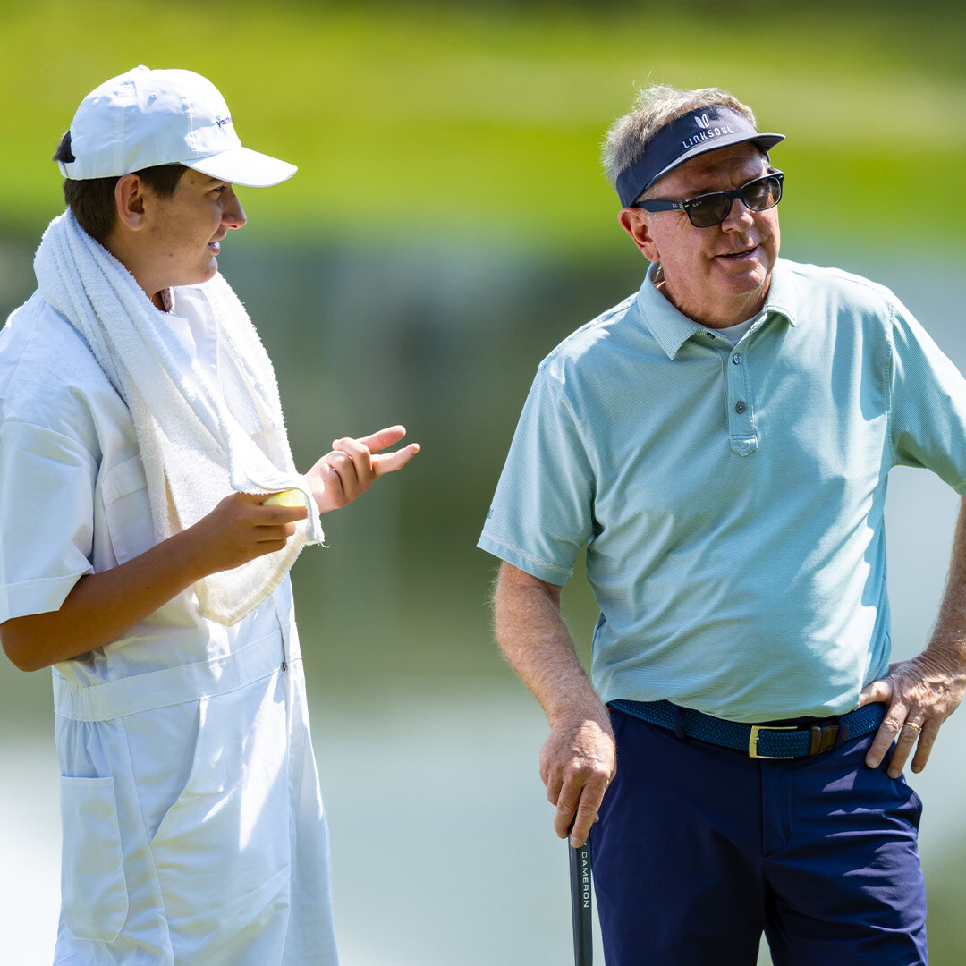 Youth on Course member caddying for amateurs alongside pros