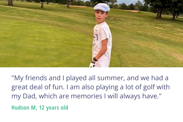 A youth golfer stands on a golf course, club in hand