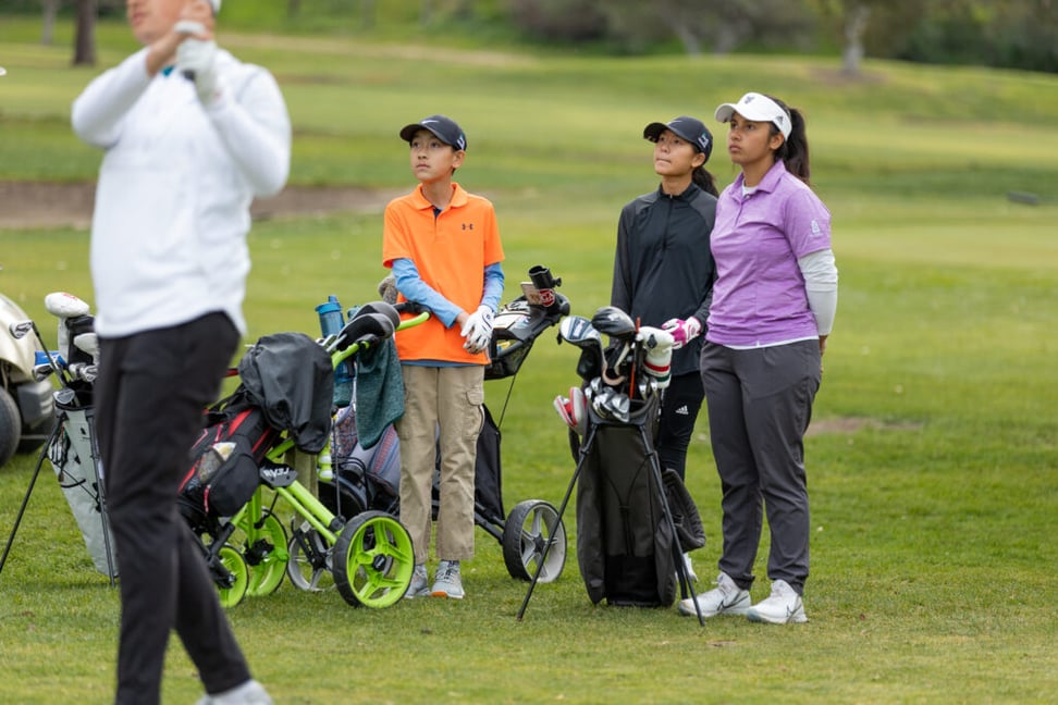 Youth on Course members watching and playing in a round of golf with their clubs