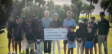 Rory McIlroy presenting a million dollar check to Youth on Course CEO Adam Heieck 