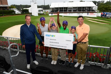 Rory McIlroy presenting a million dollar check to Youth on Course CEO Adam Heieck 