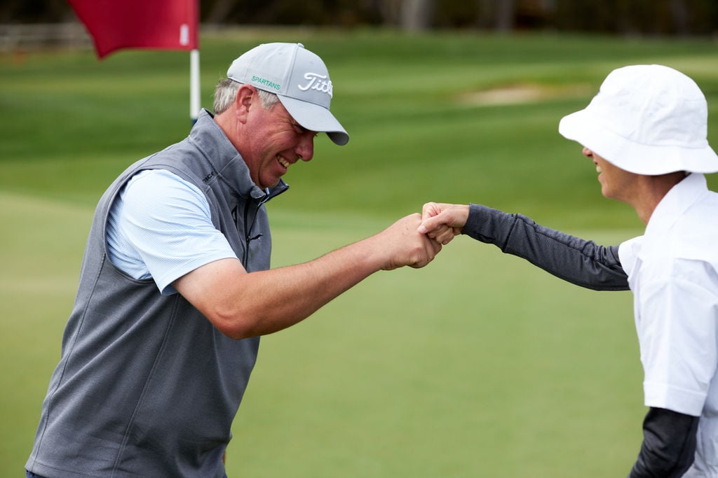 100 Hole Hikers fist bumping while playing 100 holes of golf